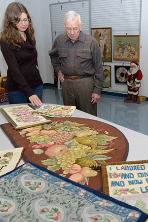 Penny G. Lutz, manager of The Gallery at Penn College, talks with Chalmer Van Horn about some of the pieces in the show.