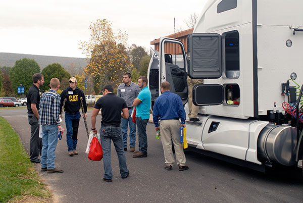 Matthew P. Zelinsky Jr. (far left), a 2009 diesel technology alumnus employed by Motor Truck-Thermo King, traveled with an attraction too large to fit inside.