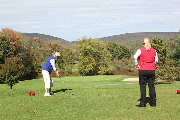 Lenore G. Penfield, director of facilities utilization and college events, tees off on the picturesque seventh hole.