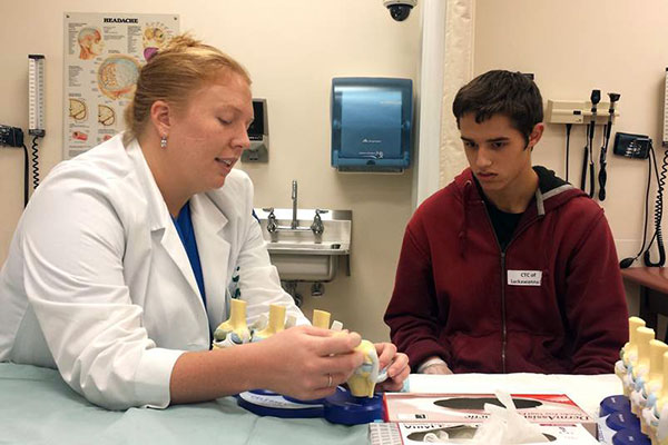Using knee models, Jessielyn L. Woolbright shows a participant the functions of the joint and its cartilages.