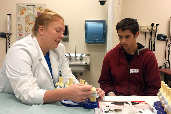 Using knee models, Jessielyn L. Woolbright shows a participant the functions of the joint and its cartilages.