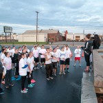 Occupational therapy assistant student Janae B. Rohrer (on fountain in ponytail) provides directions to the runners/walkers.