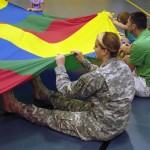 Cadet Morgan Kraus, from Bloomsburg University, works with a parachute during the schoolchildren's gym class.