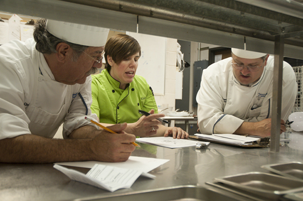 Ritchey reviews plating requirements with hospitality management/culinary arts faculty Chef Michael J. Ditchfield, instructor, and Chef Paul Mach, assistant professor.