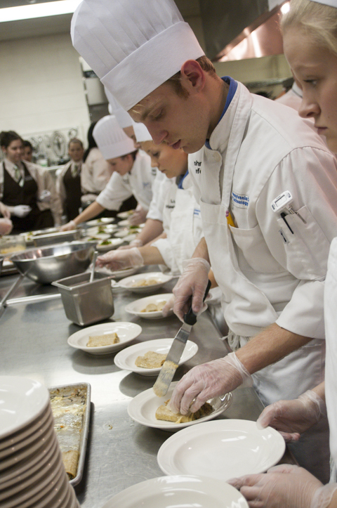 Student John A. Keefer places cannelloni in a pasta bowl.