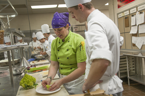 During a dinner prep session on Thursday, Chef Kristi Ritchey shows student Lewis D. Robinson how to cut romanesca for Friday’s menu.