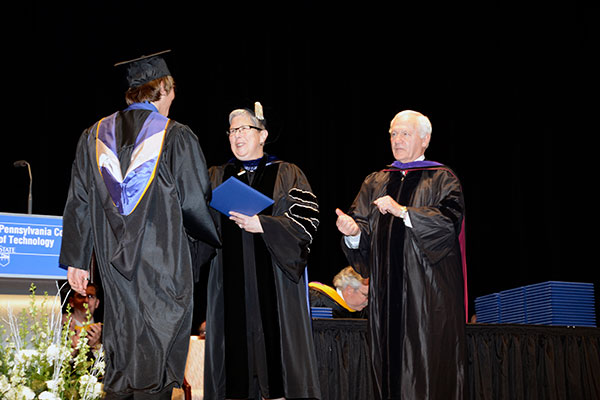 President Gilmour and Sen. Yaw congratulate the day's final graduate, student speaker Eric J. Palanko.