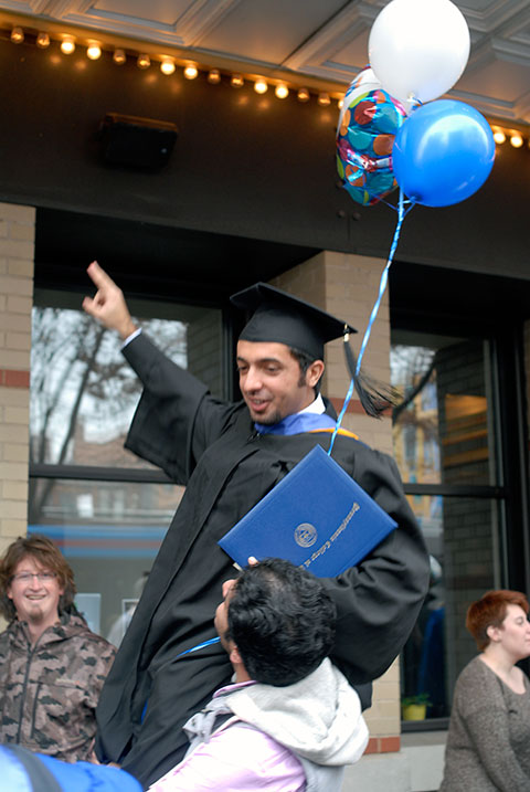 With a little help from his friends, a new alumnus is hoisted in triumph.