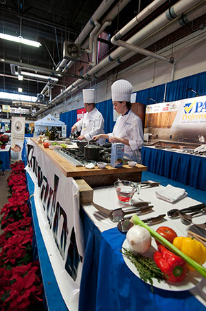 Chef Paul Mach, assistant professor of hospitality management/culinary arts at Penn College, and Victoria L. Zablocky, a culinary arts and systems major from Jersey Shore, prepare food at the 2013 Pennsylvania Farm Show.