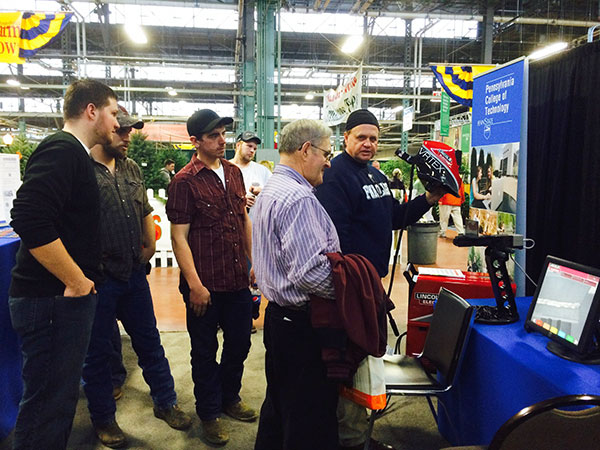 With helmet in hand, welding instructor Timothy S. Turnbach demonstrates a virtual training module.