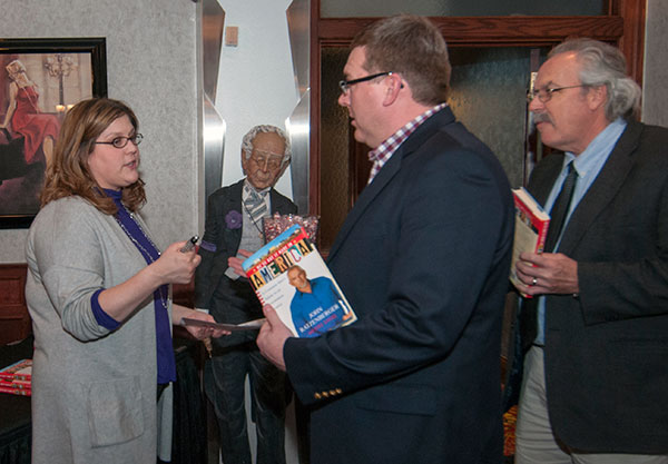 Among those at a reception and book-signing are, from left, Elizabeth G. Verbos, coordinator of admissions and enrollment event services; Elliott Strickland Jr., chief student affairs officer; and Tom Gregory, associate vice president for instruction.