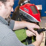 Lecturer Matthew W. Nolan guides a visitor's use of a welding simulator.