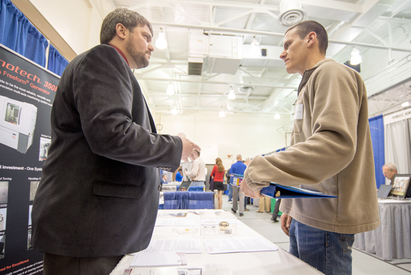 Graduate Jeffrey A. Johnson (automated manufacturing, '97) of Moore Nanotechnology explains job opportunities to student Joshua J. Saul, manufacturing engineering technology.