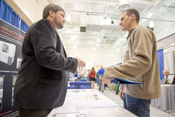 Graduate Jeffrey A. Johnson (automated manufacturing, '97) of Moore Nanotechnology explains job opportunities to student Joshua J. Saul, manufacturing engineering technology.