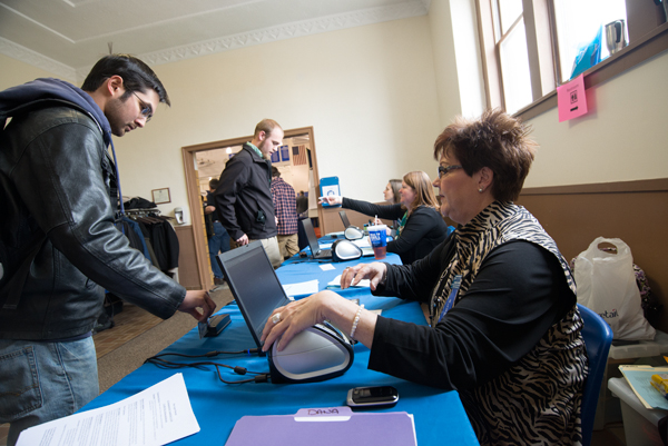 Dana R. Suter, coordinator of part-time student employment and career programs, helps students check in at Bardo Gym.