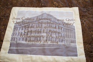 A photo of Klump Academic Center forms a fitting background to the quilt label.