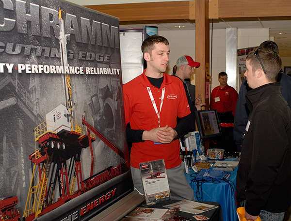 A student discusses a possible career at Schramm Inc. with 2012 alumnus Lucas J. Gilson, who holds a degree in heavy construction equipment technology: Caterpillar emphasis.