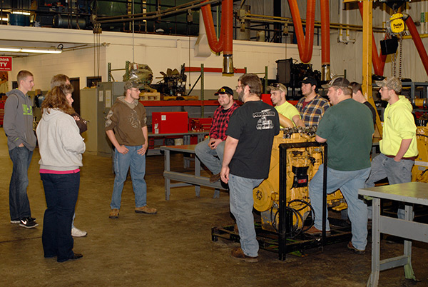 Diesel students greet a family visiting the engine lab in the School of Transportation & Natural Resources Technologies.