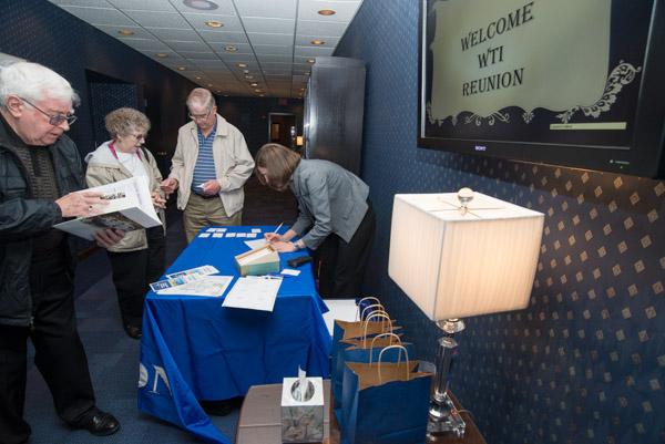 Checking in with Becky J. Shaner, alumni relations specialist, are, from left, Dyson Crownover ('60, electronics technology) and Paul Doud ('66, electrical instrumentation technician) and wife, Virginia.