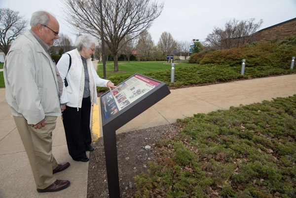 Marlyn Stauffer ('63, mechanical drafting) and wife, Darlene, enjoy the History Trail marker in front of the PDC.
