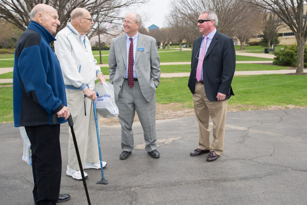 Brett A. Reasner (in sunglasses), assistant dean of transportation and natural resources technologies, and Barry R. Stiger, vice president for institutional advancement, chat with alums (from left) George Gresock ('62, electronics technology) and Earl Shive ('50, radio communications and electronics).
