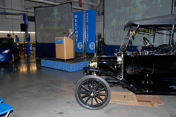 A century of automotive history is encapsulated by Colin W. Williamson, dean of transportation and natural resources technologies, standing between a new Ford C-MAX hybrid and a 1914 Model T. The dean noted that the birth of the college's automotive program coincided with a period in which contemporaries knew all manner of transportation – land, sea and air.