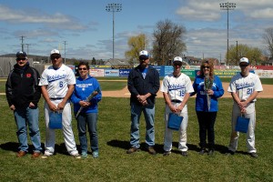 Seniors Joshua Longsderff (6), Cody (19) and Zachary Buterbaugh (21) join their parents near the first-base line for a Bowman Field tribute Sunday.
