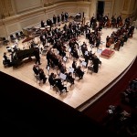 Williamson (behind the timpani at center background) joins his colleagues on stage in Carnegie Hall's 2,800-seat Isaac Stern Auditorium.