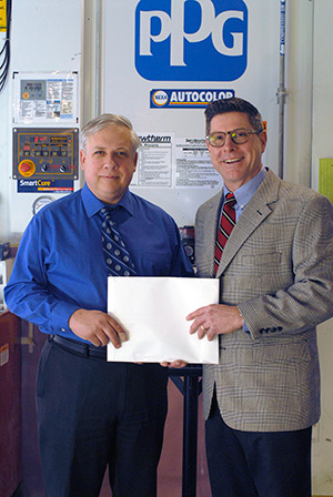 Colin W. Williamson (left), dean of Penn College’s School of Transportation & Natural Resources Technologies, and Todd Warren, PPG territory manager, affirm their ongoing partnership outside a College Avenue Labs paint-mixing room.