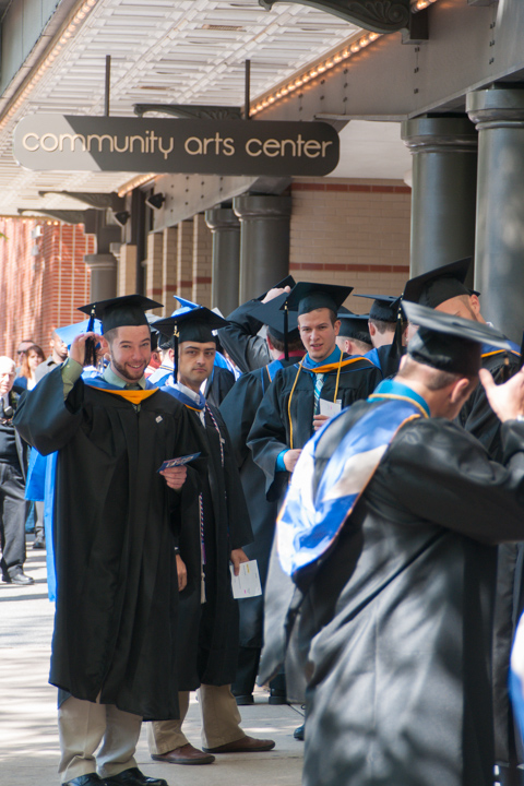 Under the Arts Center marquee, graduates check their tassels one last time before entering. 