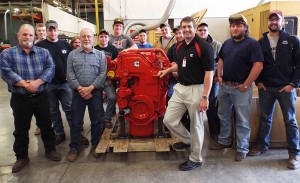 Surrounding a donated engine at Penn College’s Schneebeli Earth Science Center are (front row from left) diesel equipment technology instructors William P. Kilcoyne Jr. and David C. Johnson and Cummins Inc.'s Shawn M. Hricko, joined by students from Johnson’s Vehicle Electronics/Diagnostic Procedures lab.