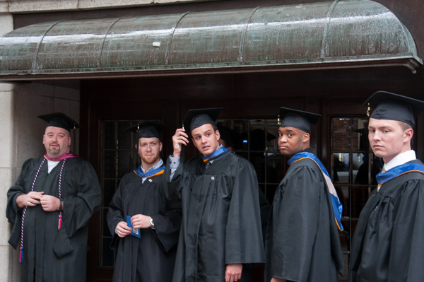 During a pause in the procession, Wayne R. Sheppard, assistant professor of construction management and building construction, and students find shelter from the rain.