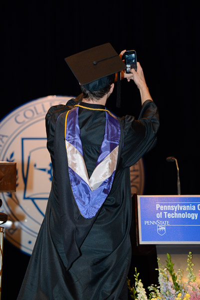 Saturday morning’s student speaker Benjamin M. Schappell snaps a ‘selfie” on stage while delivering his address.