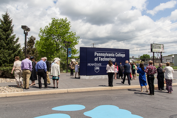 Grads capture their photo at the Penn College entrance sign.