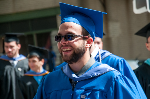 A soon-to-graduate student beams on his walk toward the arts center.