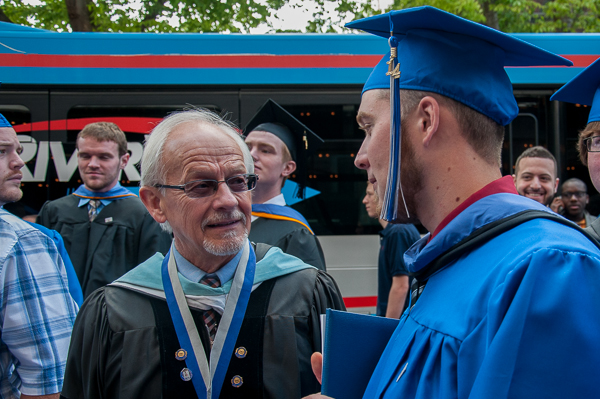 Celebrating his last commencement before retirement, Master Teacher Dennis F. Ringling, professor of forestry, chats with a student.