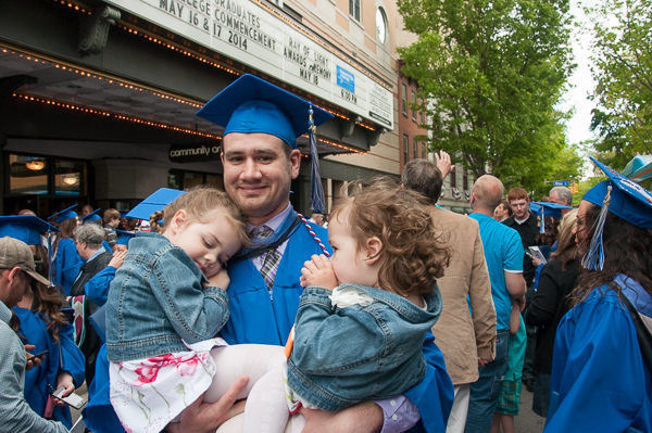 Snuggles from his daughters help a graduate celebrate.