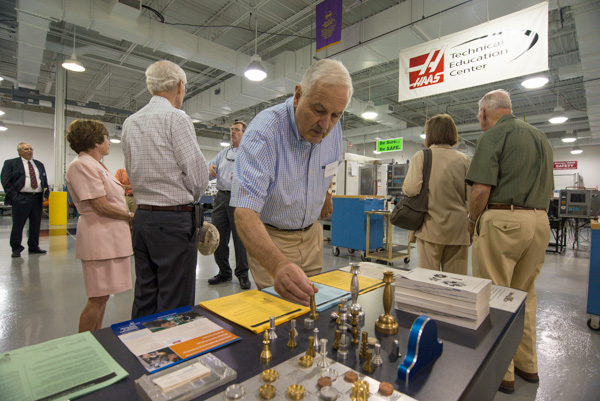 Edmond A. Watters III, who served as dean for degree and certificate programs from 1978-81, investigates creations in the manufacturing technology lab. 