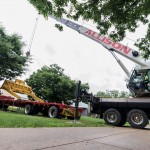 A commemorative heavy-construction blade is lifted off the truck ...