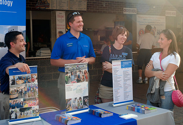 Sharing their Penn College Pride (from left), Joseph J. Balduino, director of recruitment, and admissions representatives Sean M. Stout and Sarah R. Shott staff an information table.