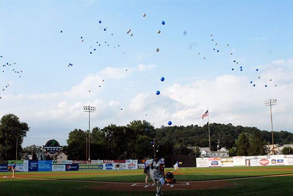 One hundred balloons, launched by four students during pregame festivities, catch a scant breeze over the stadium.