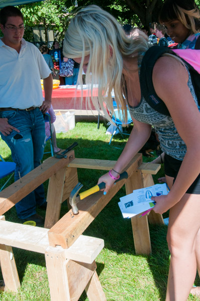 A student tests her hammering hand at the School of Construction & Design Technologies booth.