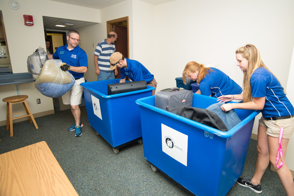A “blue crew” makes speedy work of a Clinton Hall move-in. From left are Jeffrey D. Filko, assistant director I, dining services; Bradley M. Webb, director of student affairs administration; and resident assistants Kailie T. Messerman from Lewistown and Jenna E. Kline, of Selinsgrove, both sophomores in nursing … 