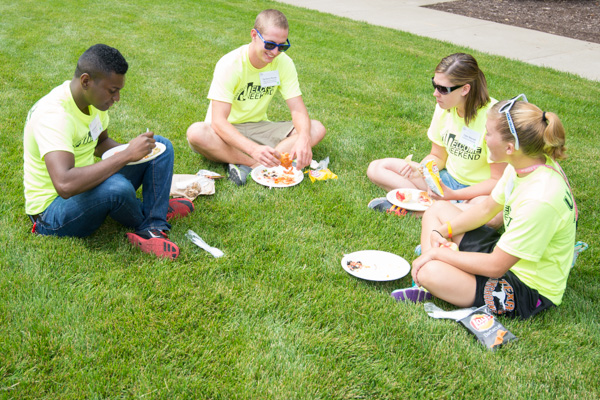 Student volunteers find a sweet spot on the grass to enjoy lunch, rest and conversation.