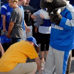 Dennis L. Correll, associate dean of admissions and financial aid, helps the college mascot avoid soggy sneakers.