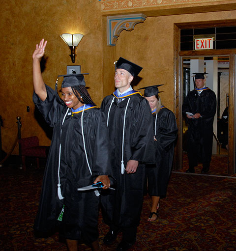 Students acknowledge their faculty supporters upon entry to the theater.