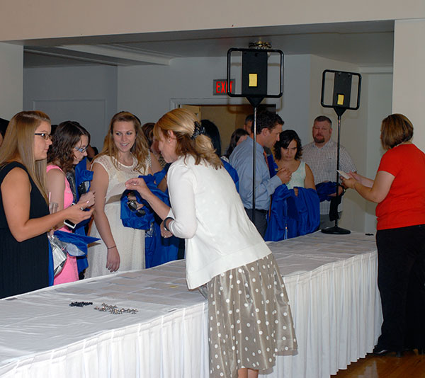 Graduating students receive their marching orders, honors cords and Centennial pins from Katie M. Reed (center foreground), registrar office <br />
<br />
assistant, and Heather A. Swimley, assistant registrar.