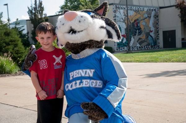 The Wildcat makes fast friends during the cross-campus trek to the parade route.