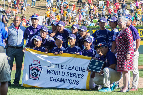 Penn College President Davie Jane Gilmour joins the Asia-Pacific team on the field after its 8-4 victory in Sunday's championship game.