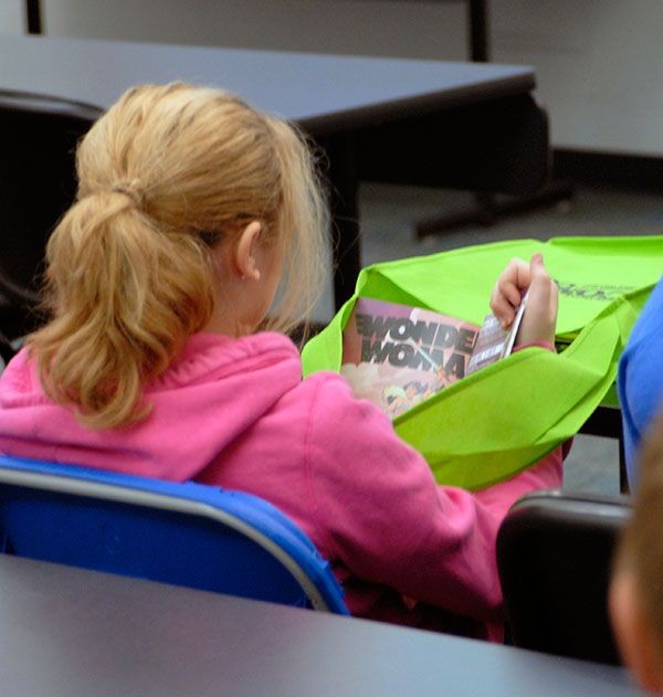 Paging through the day's giveaway comic books, a young girl makes an empowering find.